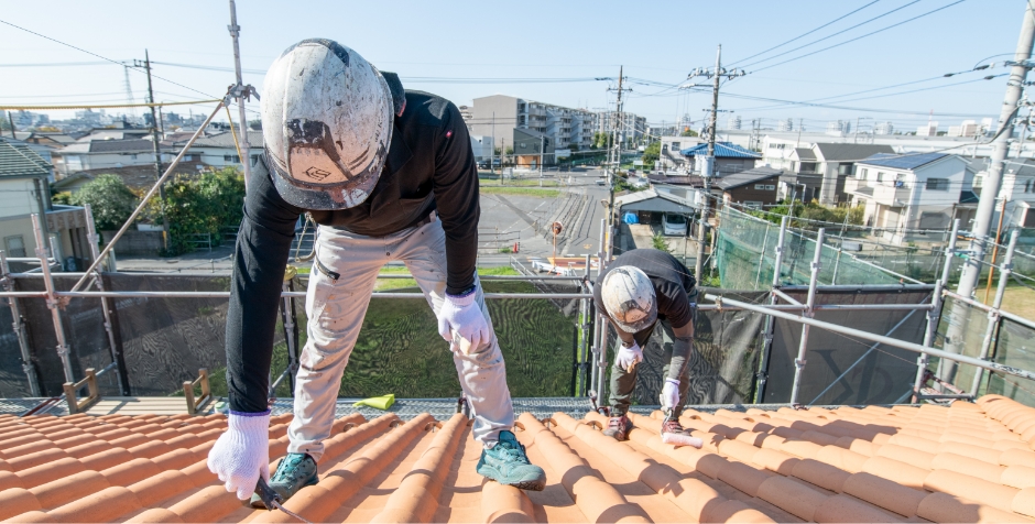 屋根に登って塗装工事をしている様子