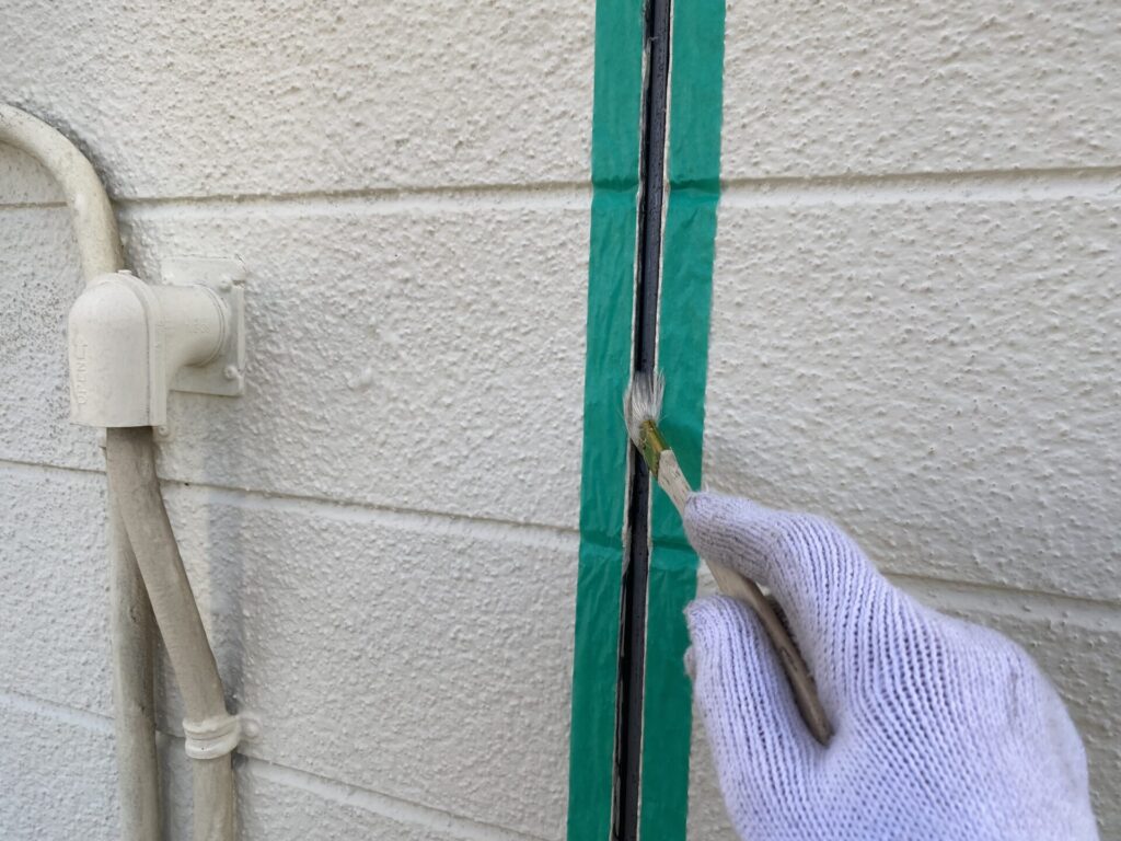 コーキング材の密着性を高めるため、目地の内部に刷毛でプライマーを塗布する工程。