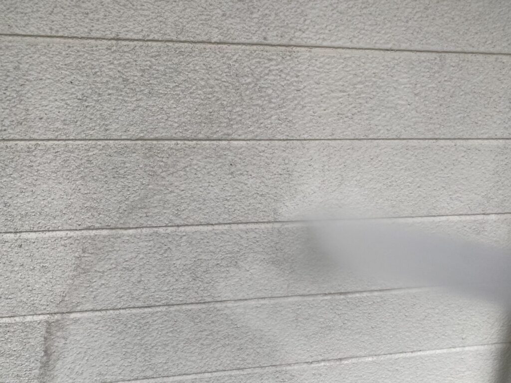 住宅の外壁塗装下地作り：高圧洗浄機を使い、壁全体の埃や古い塗膜の粉（チョーキング）を除去する工程