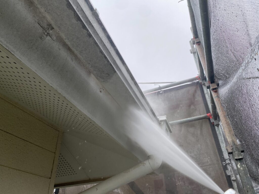 雨樋の高圧洗浄：足場を活かして、樋の内側や外側に付着したカビ・泥汚れを隅々まで清掃する工程