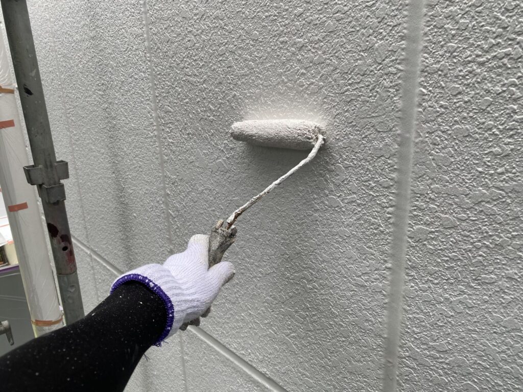 お客様が選ばれた仕上がり色の塗料を使い、塗膜に必要な厚み（膜厚）を持たせるために外壁全体へ丁寧に中塗りを行う工程。