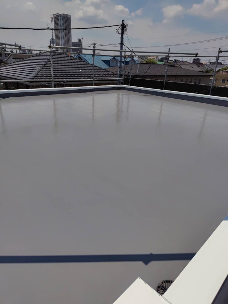 トップコートが乾燥し、水はけが良くピカピカで美しい鏡面状に仕上がった、雨漏り対策万全のベランダ・屋上防水工事の完了写真。