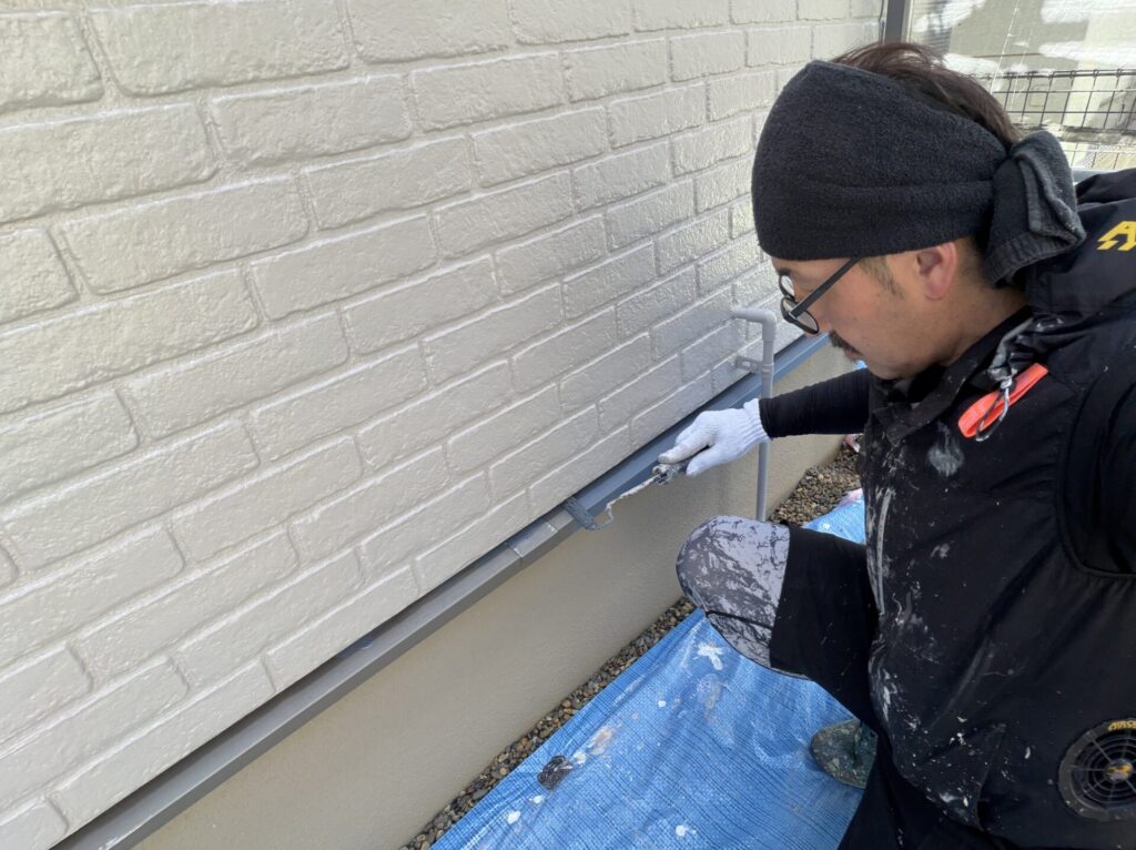 水切りへ錆止め塗料（下塗り）を丁寧に塗布する作業風景