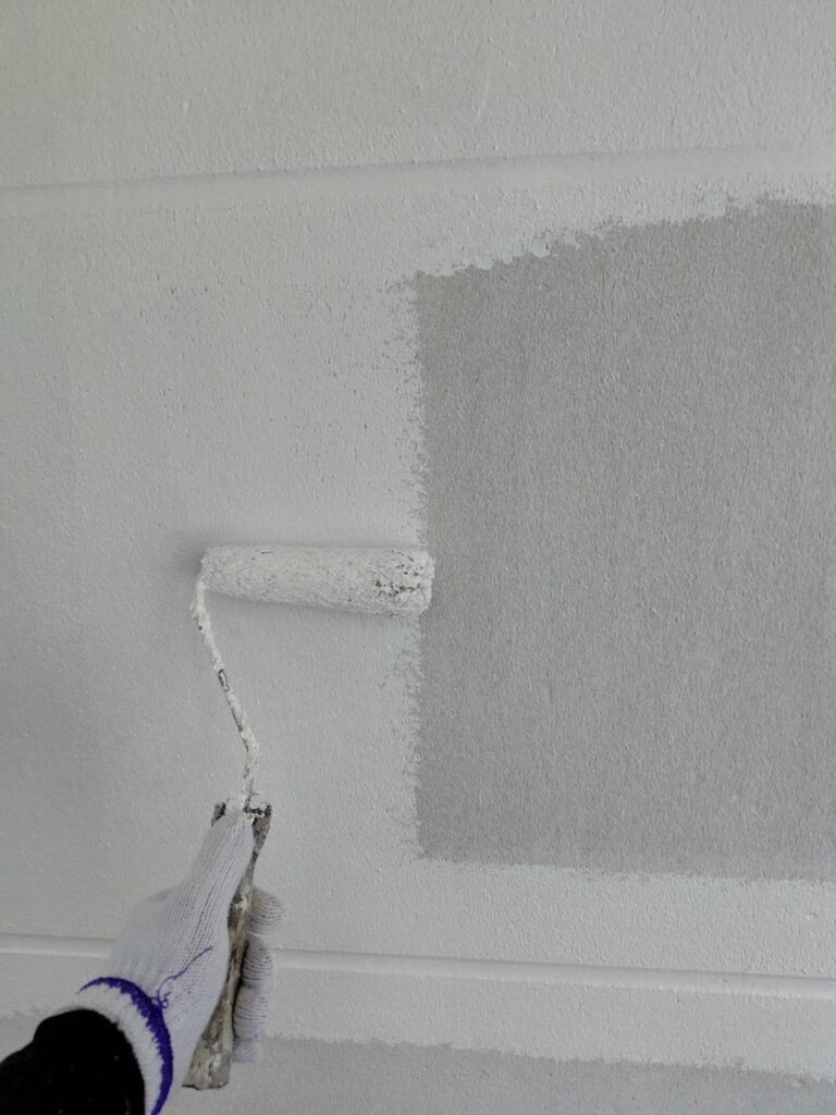外壁面全体へ均一な塗膜を形成しながら中塗りを仕上げていく作業風景