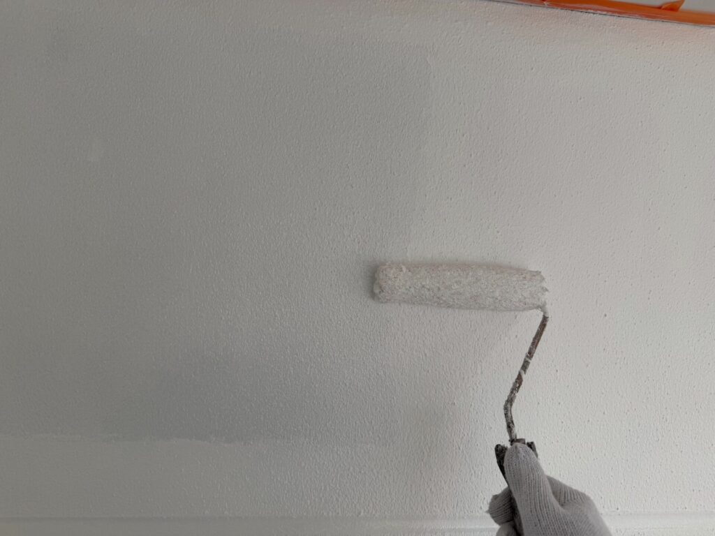 足場から手の届きにくい高所や細部まで丁寧に上塗りを重ねる職人