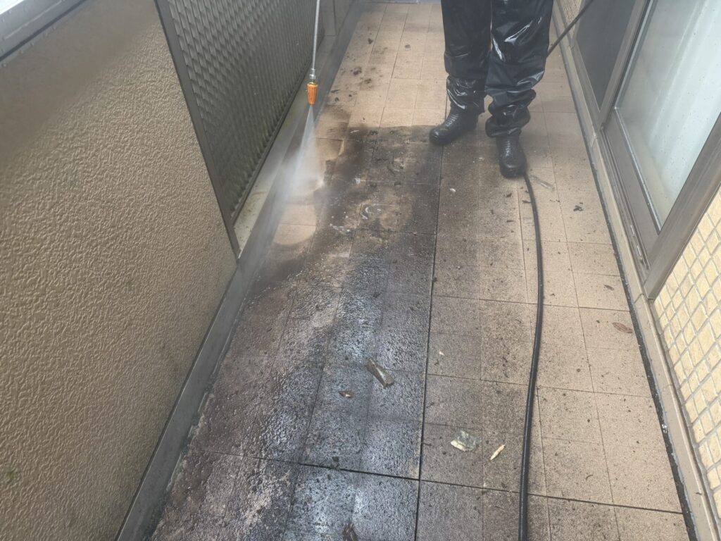 バルコニー床面に溜まった黒ずみや泥汚れを高圧洗浄