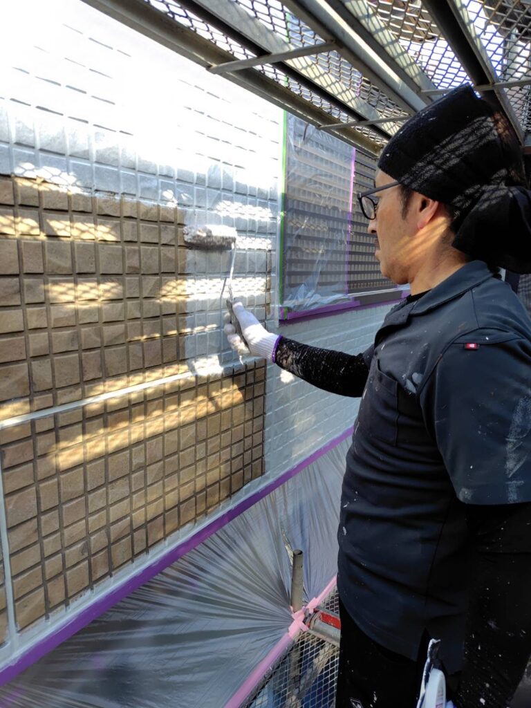 タイル柄の凹凸に合わせてローラーでムラなく下塗りを塗り進める職人