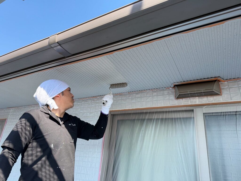 中塗り乾燥後、さらに塗膜を厚くするため軒天の上塗り(2回目塗装)を行う様子