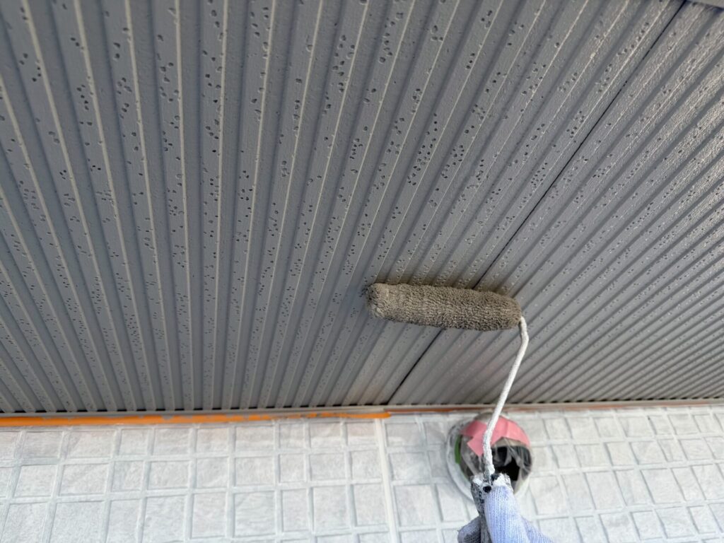 中塗り乾燥後、さらに塗膜を厚くするため軒天の上塗り(2回目塗装)を行う様子